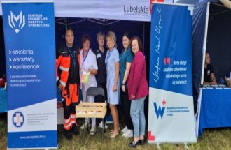 Pracownicy medyczni Wojewódzkiego Szpitala Specialistycznego w Lublinie stojący przy stoisku z materiałami informacyjnymi i punktem mierzenia ciśnienia na dorzynkach wojewódzkich w Świdniku.