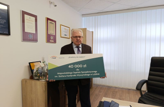 Dyrektor Wojewódzkiego Szpitala Specjalistcznego trzyma w ręku symboliczny zcek na 40 tysięcy zł od PGE