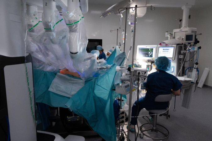 Siedzący plecami Anestezjolog w trakcie operacji z użyciem robota daVinci