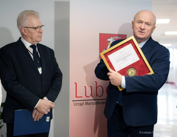 Marszałek Jarosław Stawiarski wraz z dyrektorem Wojewdzkiego Szpitala Specjalistycznego Piotrem Matejem prezentujący oprawiony w ramkę Medal 550 Lecia Województw Lubelskiego